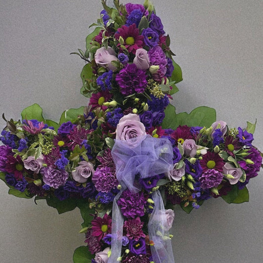 Elegant Purple Cross floral tribute with lavender flowers, symbolizing peace and spirituality, ideal for sympathy and funeral arrangements.