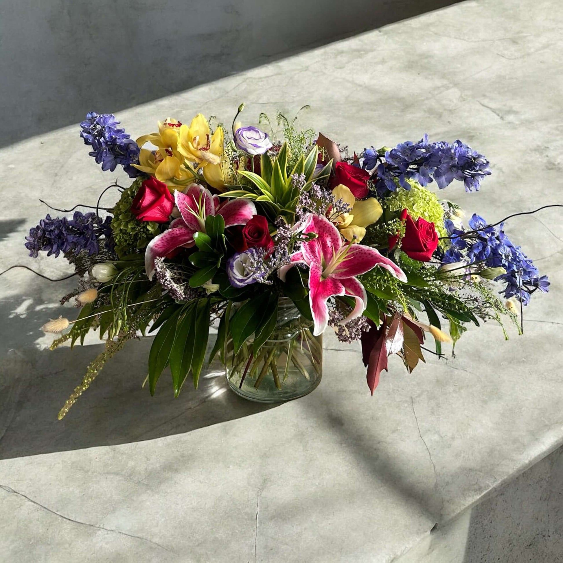 Enchanted Garden Bouquet featuring roses, lilies, orchids and delphiniums in a luxury arrangement for same day delivery in Toronto.
